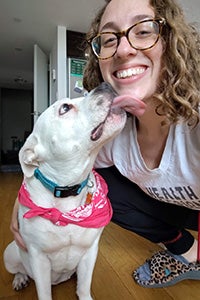 Zena the dog giving a kiss to the chin of a smiling woman