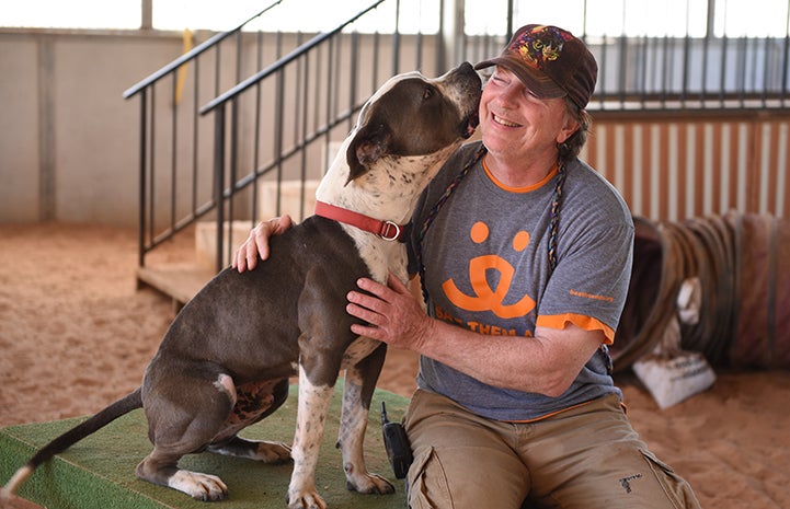 Tom the Dogtown caregiver sitting next to Jango the dog