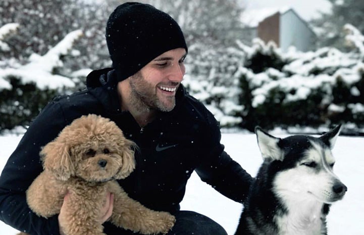 Tyler Rich with dogs Abby and Charlee playing in the snow