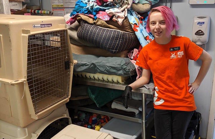 Bella Brodie the volunteer standing next to some large plastic kennels