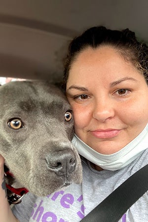 Selfie of a smiling person next to a big, gray dog