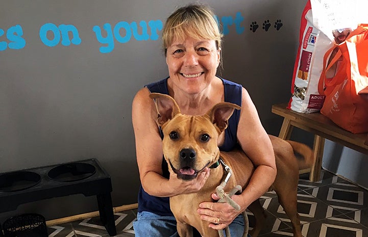 Woman foster mom hugging Samwell the dog