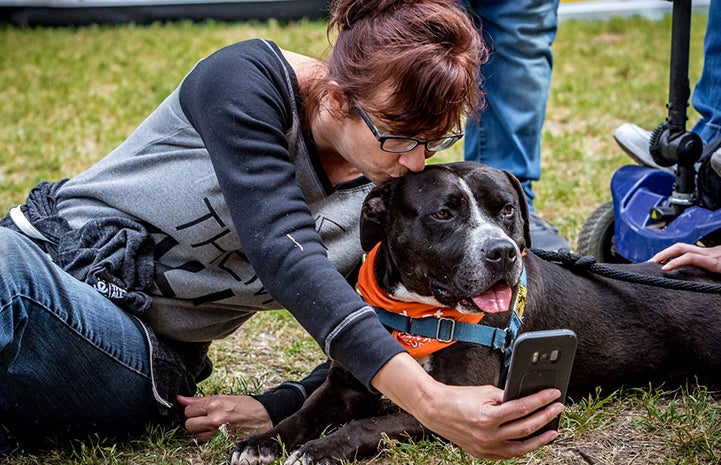 Michelle Sathe taking a selfie with Huck the black and white pit bull terrier