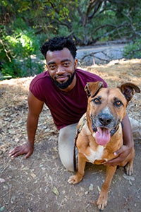 Brandon Alexander with his arm around Bear the dog