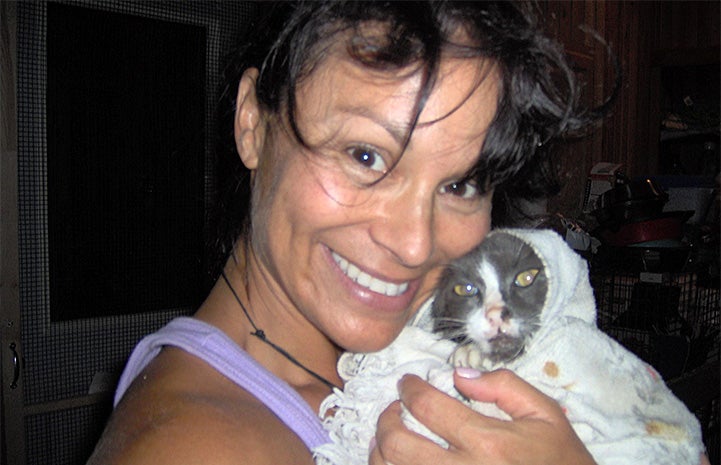 Lisa Moretti snuggling with Baxter the cat in a blanket