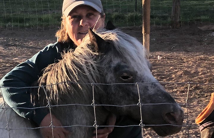 Woman hugging Fury the miniature horse