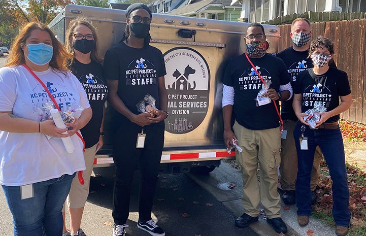 Kansas City Pet Project animal services team officers standing behind a truck while out in the field