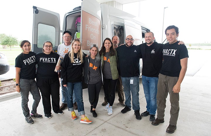 Group of people standing in front of a transport van