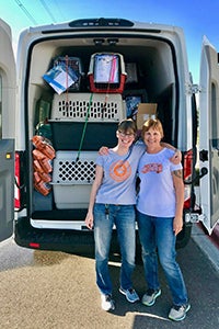 Heidi Losleben and Linda Blauch in front of the transport van