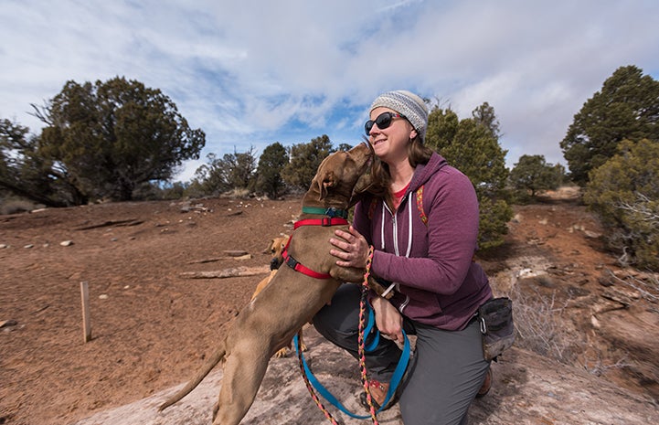 Cosette the dog giving caregiver Jess a kiss