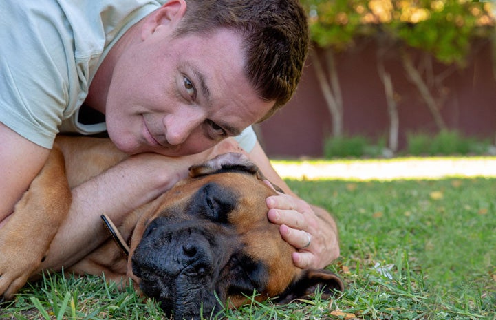 Man lying in the grass with Santiago the mastiff