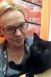 Belle Henderson the volunteer holding a black cat