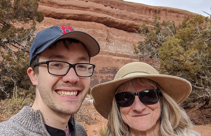 Volunteer Judy Steiger with another person in front of a rock outcropping