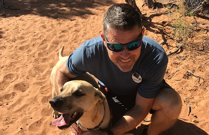 Volunteer Kevin Wesely hugging Moqui the dog