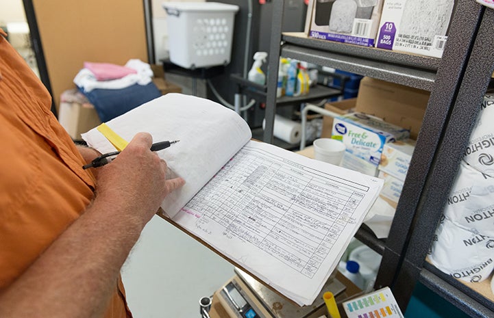 Doug Stockdale makes careful notes in the koi fish log book