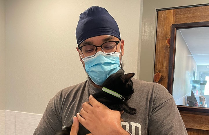 Volunteer Ramandeep Singh holding a black kitten