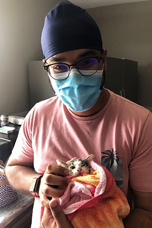 Ramandeep Singh the volunteer holding a kitten in a towel