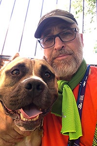 Volunteer David Glazer next to Beefy the dog