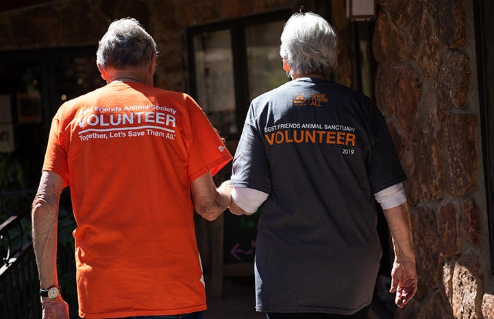 The backs of Mary Rose and Vann Hollie, both wearing Best Friends volunteer T-shirts