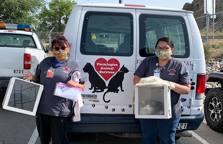 Two people from Farmington Animal Services holding boxes to return community cats