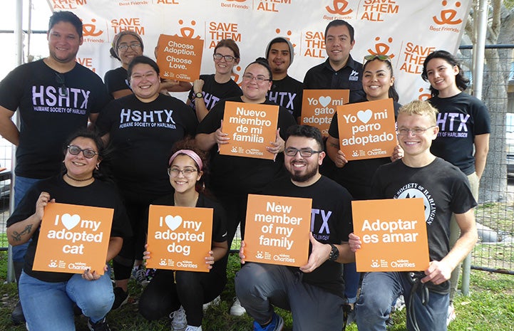 Group of people from HSHTX with some adoption signs, some in English and some in Spanish