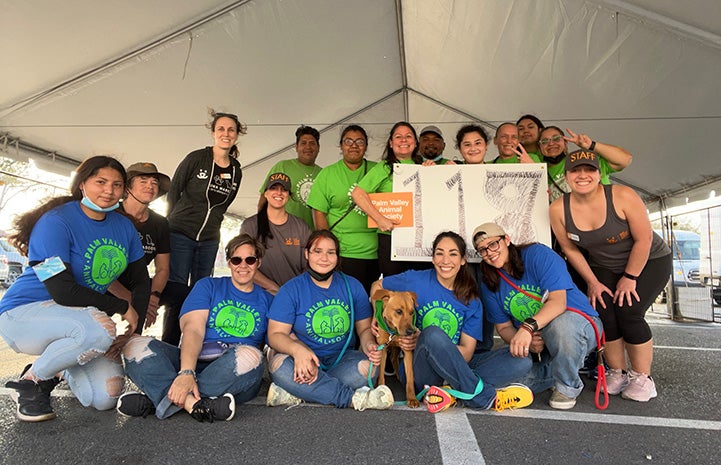 Group of people with a dog, holding a sign that says 117