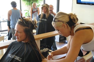 Paul Mitchell student cutting woman's hair at Best Friends Animal Sanctuary