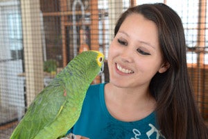 Parrot intern Kaila Huhtasaari of Pelkie, Michigan, holding a parrot 