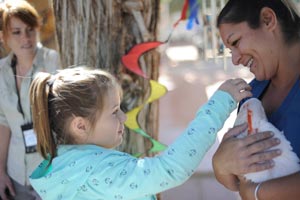 Young girl meeting a parrot at Kids Camp at Best Friends Animal Sanctuary in Utah