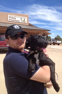 Brian, the son of the founder of Fearless Kitty Rescue, with Coltrane the puppy in from of the Puppy Preschool at Best Friends Animal Sanctuary