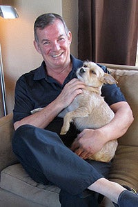 Ray holding Darby the dog who rescued him after his fall