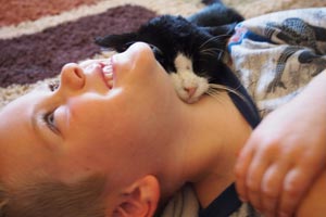 Dexter the super-senior cat snuggling with boy