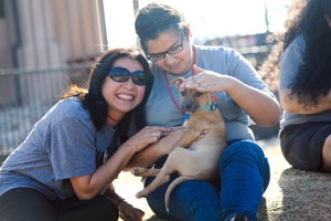 Two women enjoying snuggling with a puppy