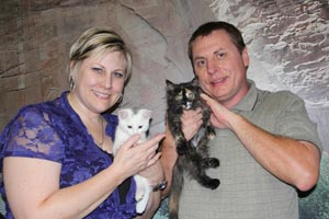 Couple holding two kittens they adopted