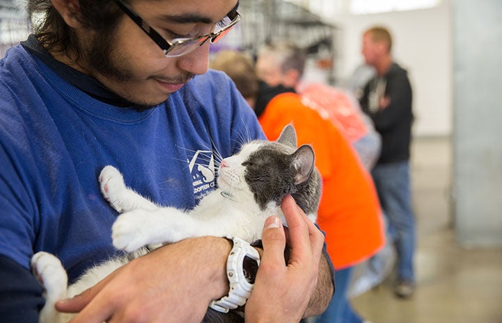 Man cradling a cat in his arms