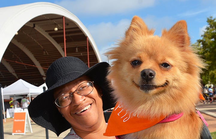 Woman smiling and holding small dog at Strut Your Mutt