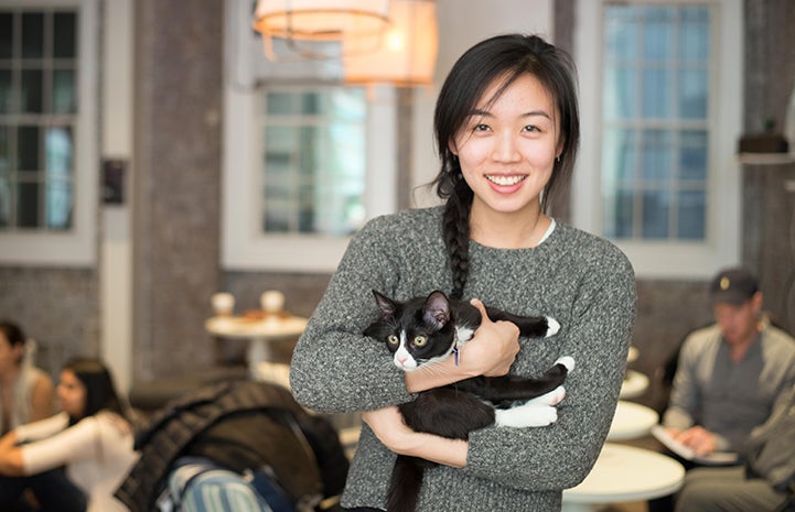 Woman enjoying time with the kitties at Little Lions Cafe in New York