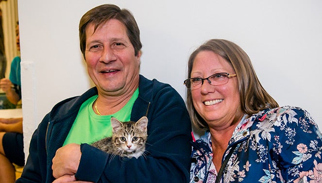 Couple holding their adopted kitten