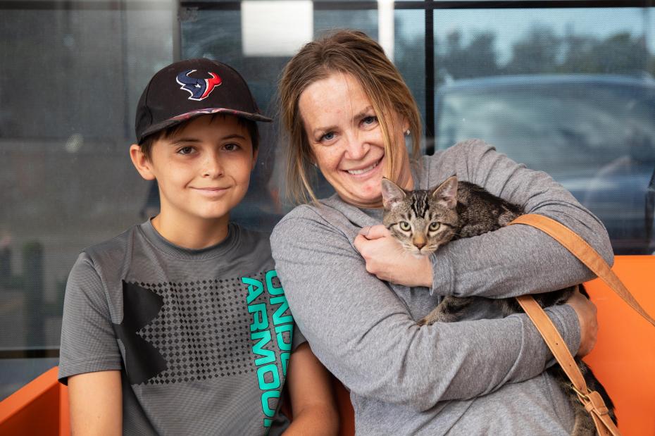 Smiling family adopting a tabby cat