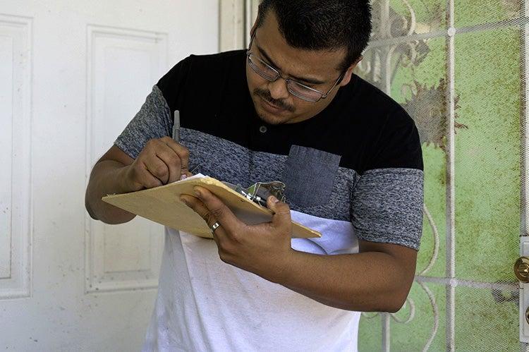 Man signing a piece of paper in a folder