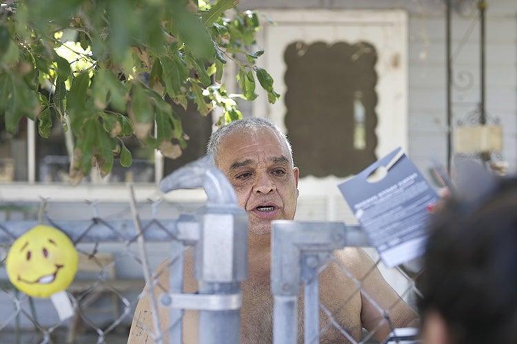 Person talking to man over a fence