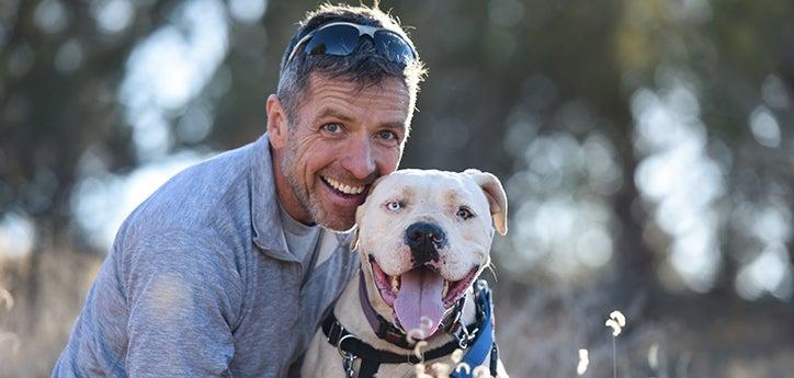 man posing with smiling white dog