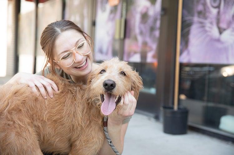 Smiling person hugging a shaggy dog