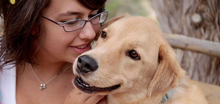 person cuddling with golden dog