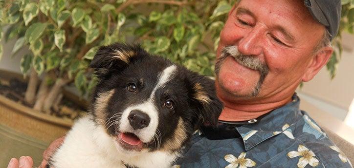 person and dog sitting together and smiling