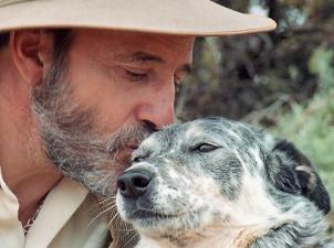 Francis kissing grey and white dog