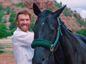 Michael Mountain with a horse in front of a red cliff of Angel Canyon