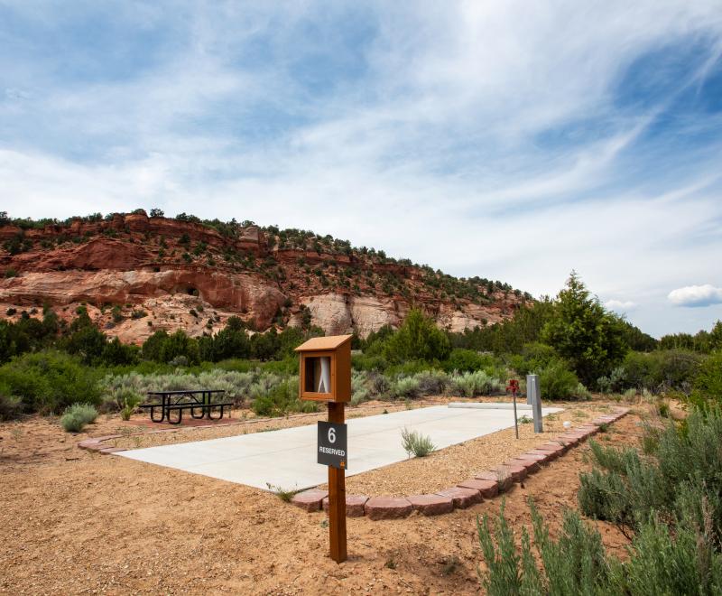 RV site with a backdrop of red rock cliffs and blue sky