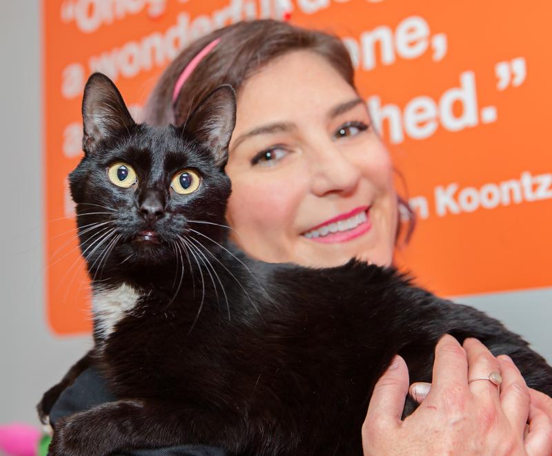 Samantha Bell holding a black and white cat