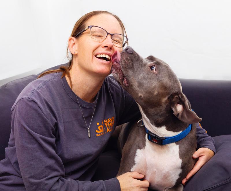 Smiling person sitting next to a dog